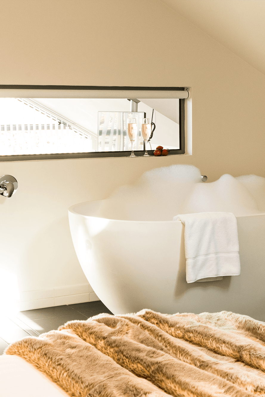 A bathtub in Room 22 at Salamanca Wharf flowing with bubbles and wine